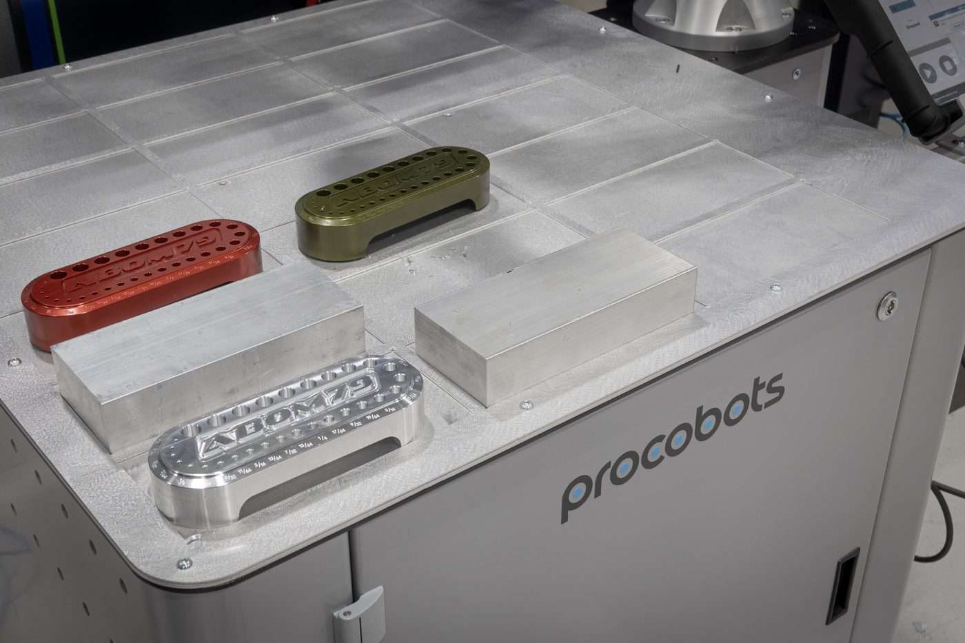 Procobots ProFeeder grid table holding raw aluminum blanks and finished anodized drill index parts